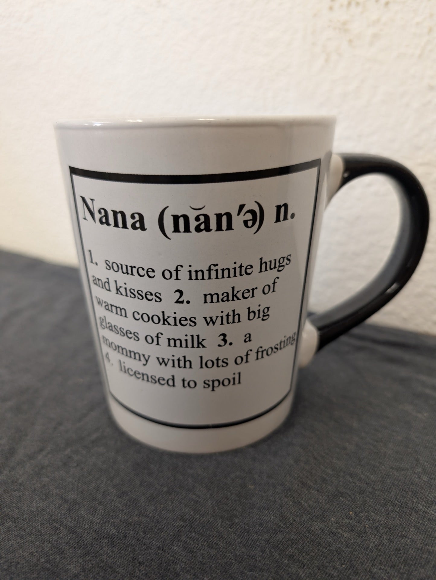 White ceramic mug with a black handle and a printed dictionary definition of the word Nana.