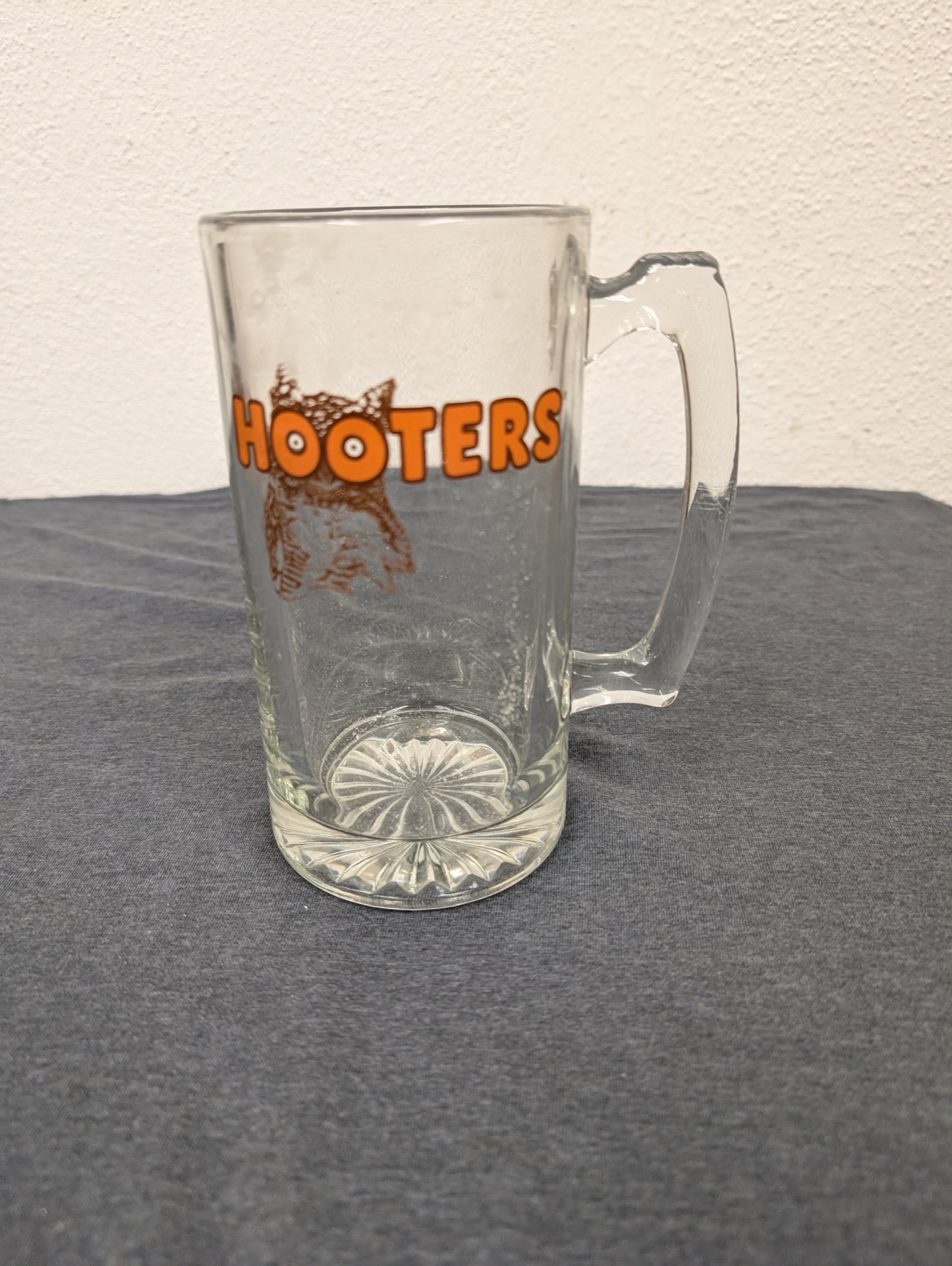 Clear heavy glass beer mug with the orange Hooters logo.