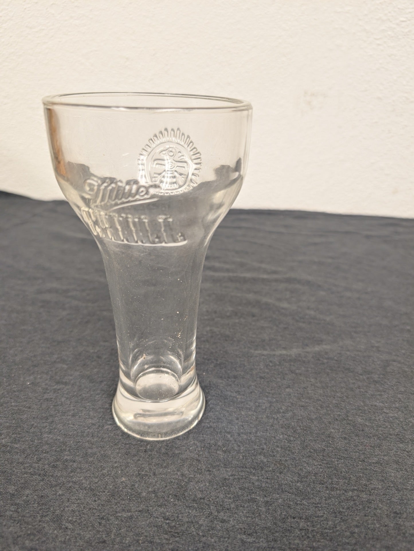 Tall clear glass with a flared top and embossed Miller High Life logo.