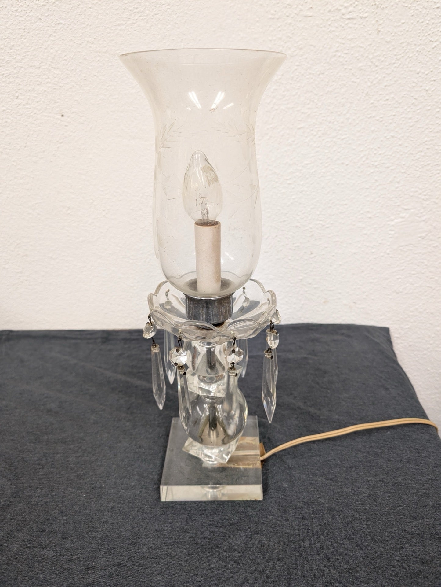 Electric table lamp with a clear square base, hanging crystal prisms, and a glass shade.