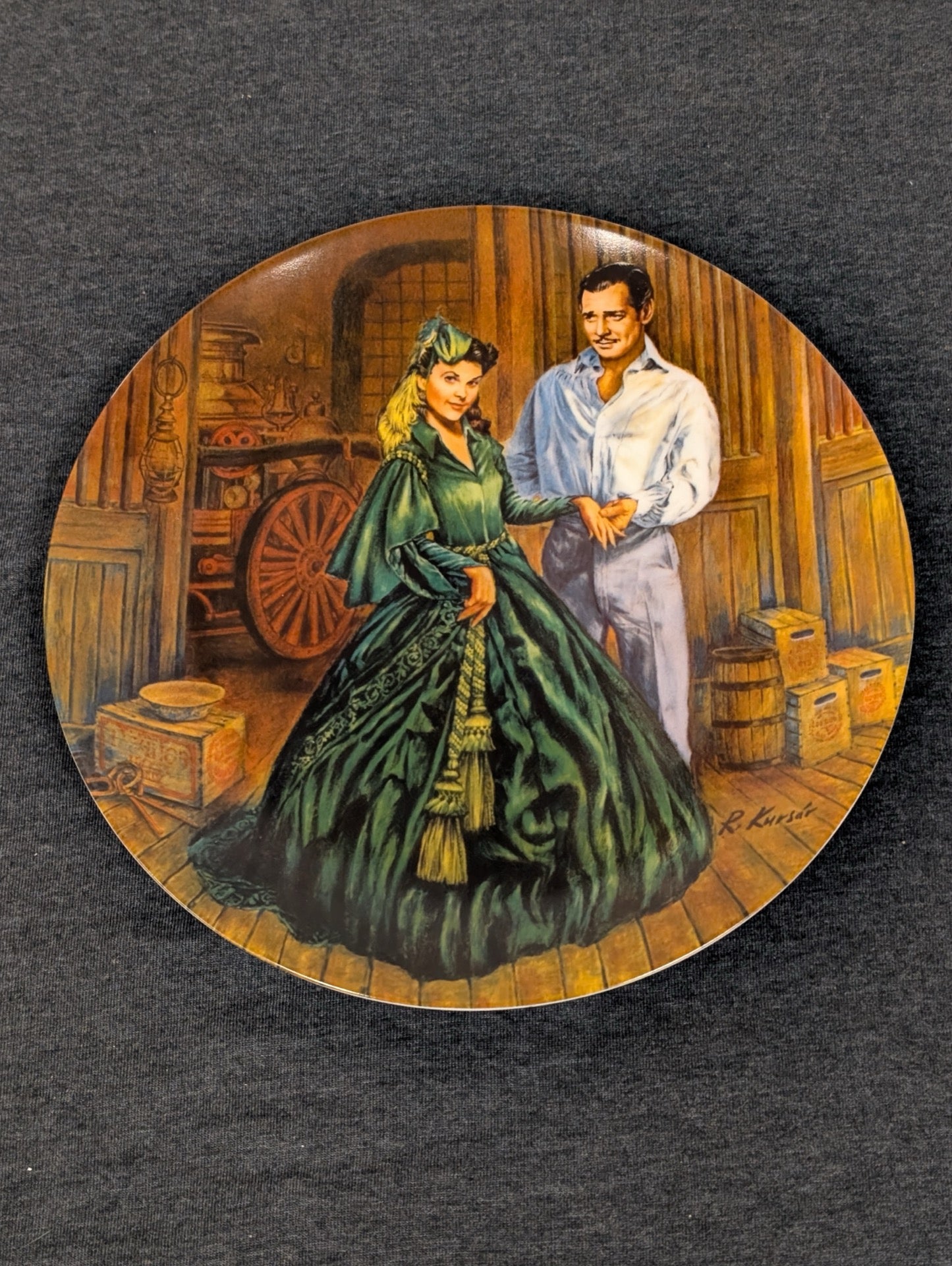 Collector plate showing Scarlett O'Hara in a green dress and Rhett Butler in a room.