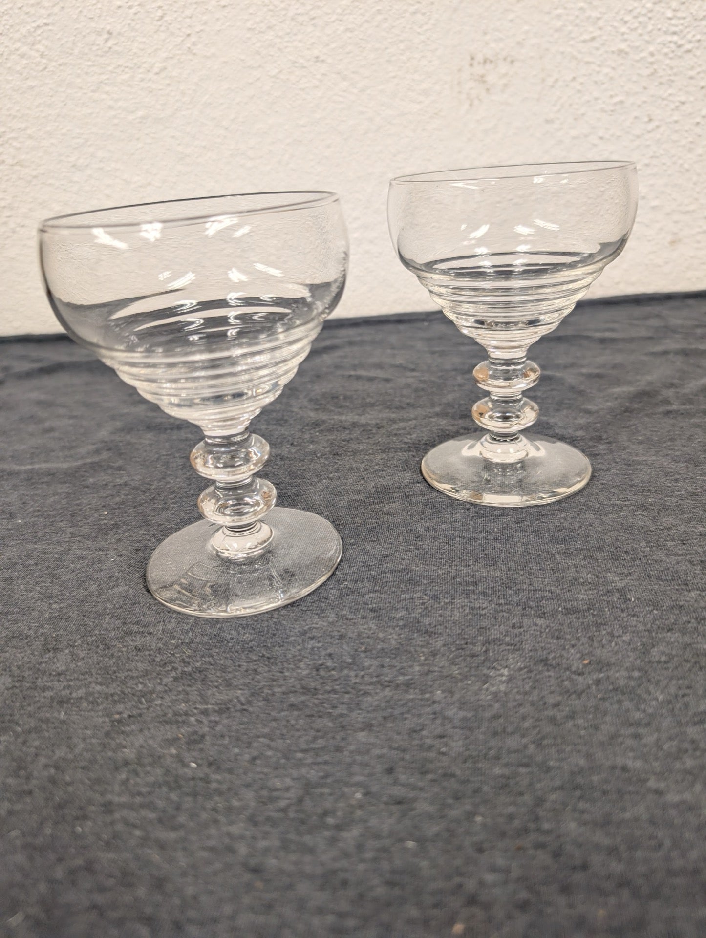 Two ribbed clear glass coupe cocktail glasses with tiered double-ball stems.