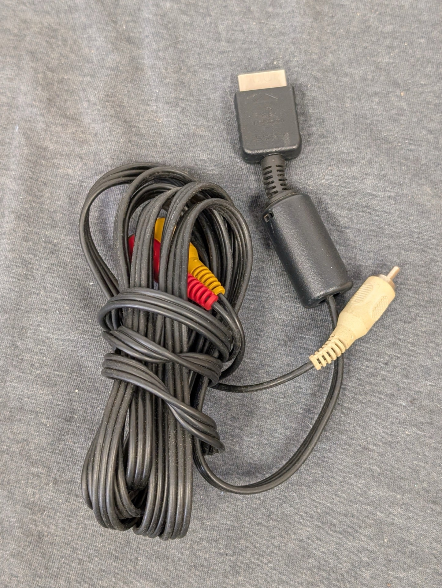 Black Sony PlayStation AV multi out cable coiled up
