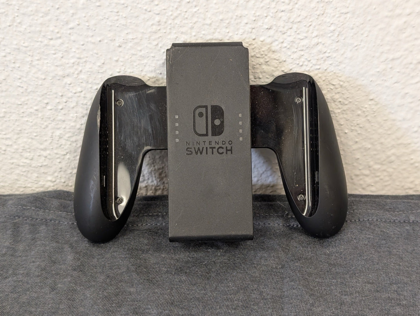 Black official Nintendo Switch Joy-Con grip heavily scratched