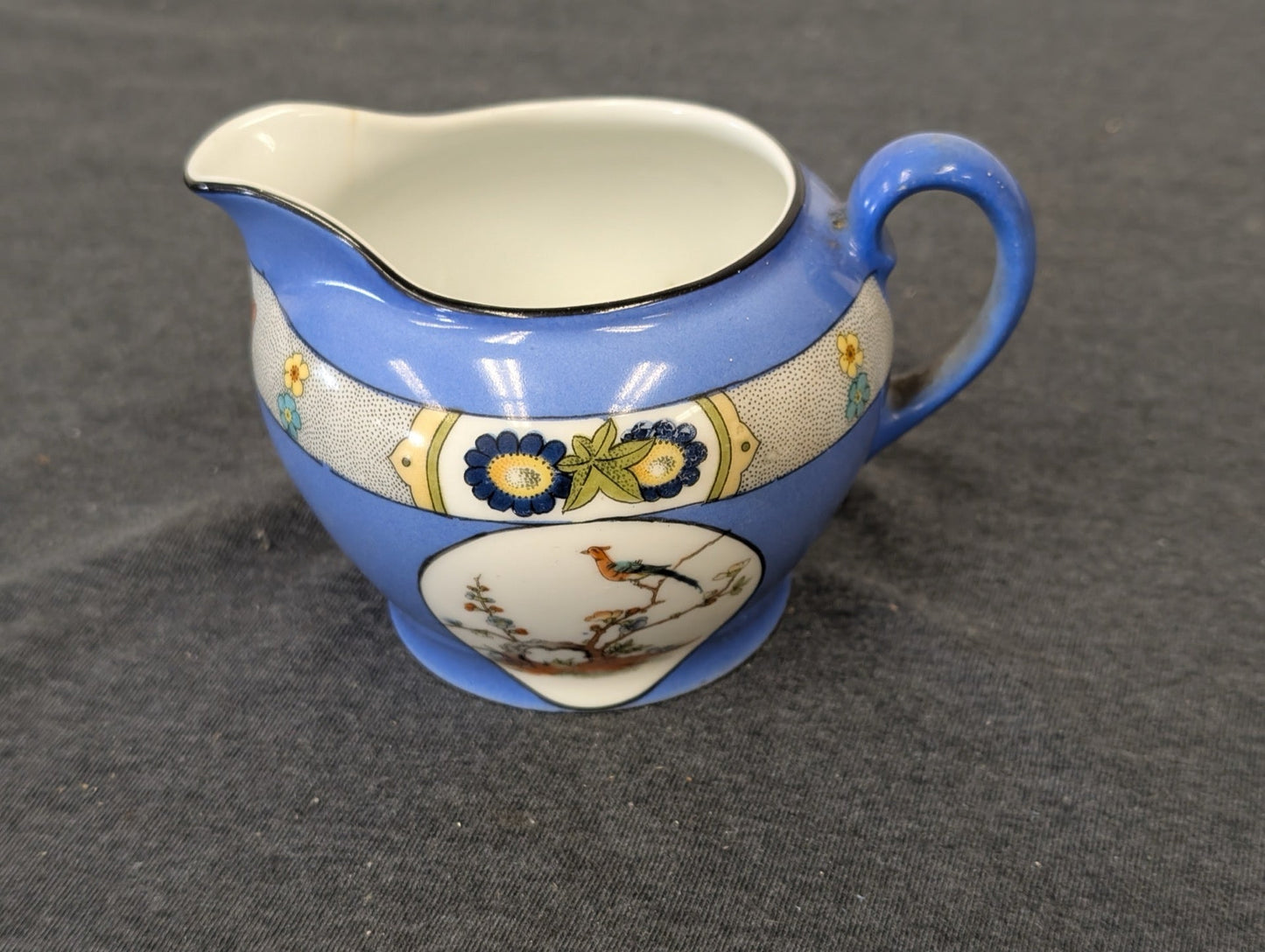 Antique Victoria Czecho-Slovakia blue creamer pitcher featuring a bird on a branch