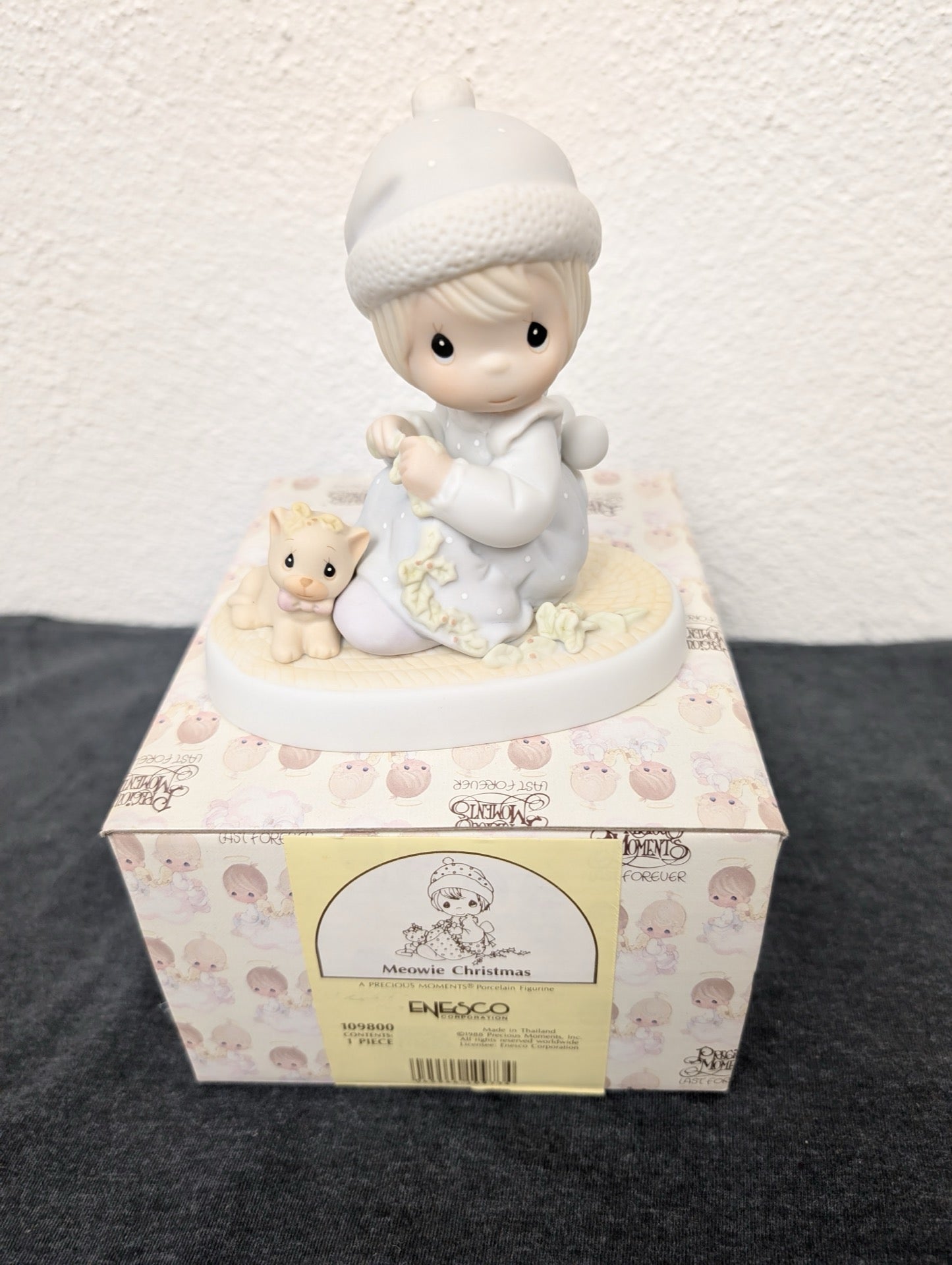 Precious Moments figurine of a girl and kitten sitting on its original box