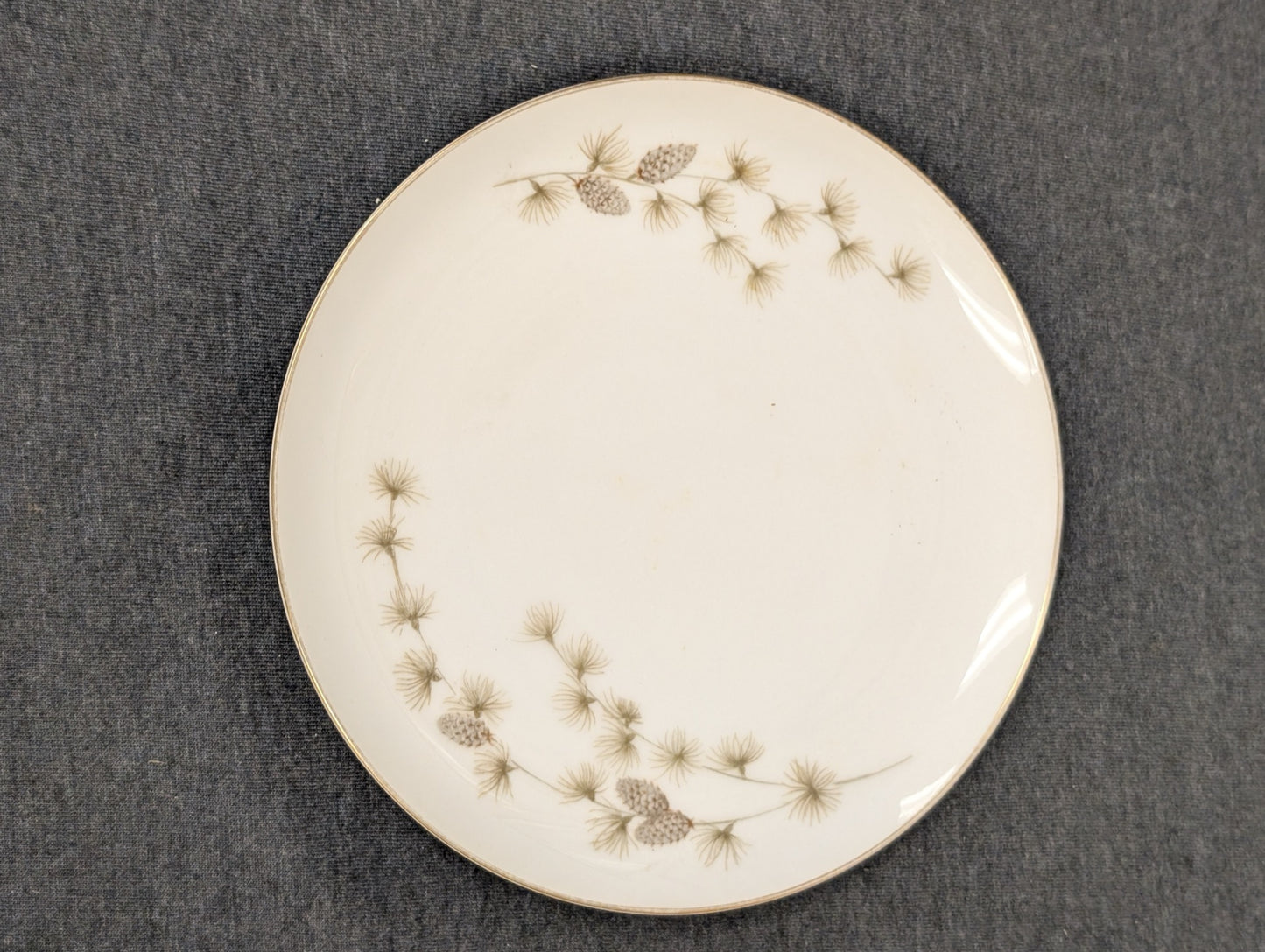 Vintage Mikasa plate with pinecone and pine needle design with gold rim.