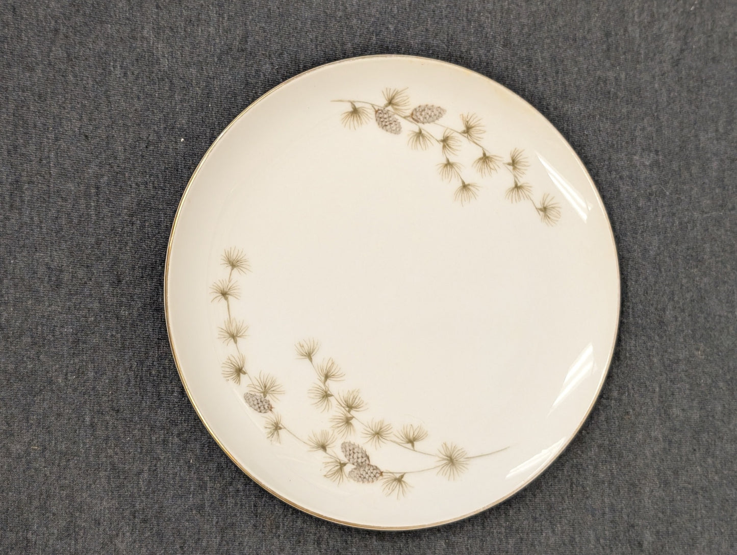 Vintage Mikasa Sequoia dinner plate featuring a pinecone design and gold trim on white fine china.