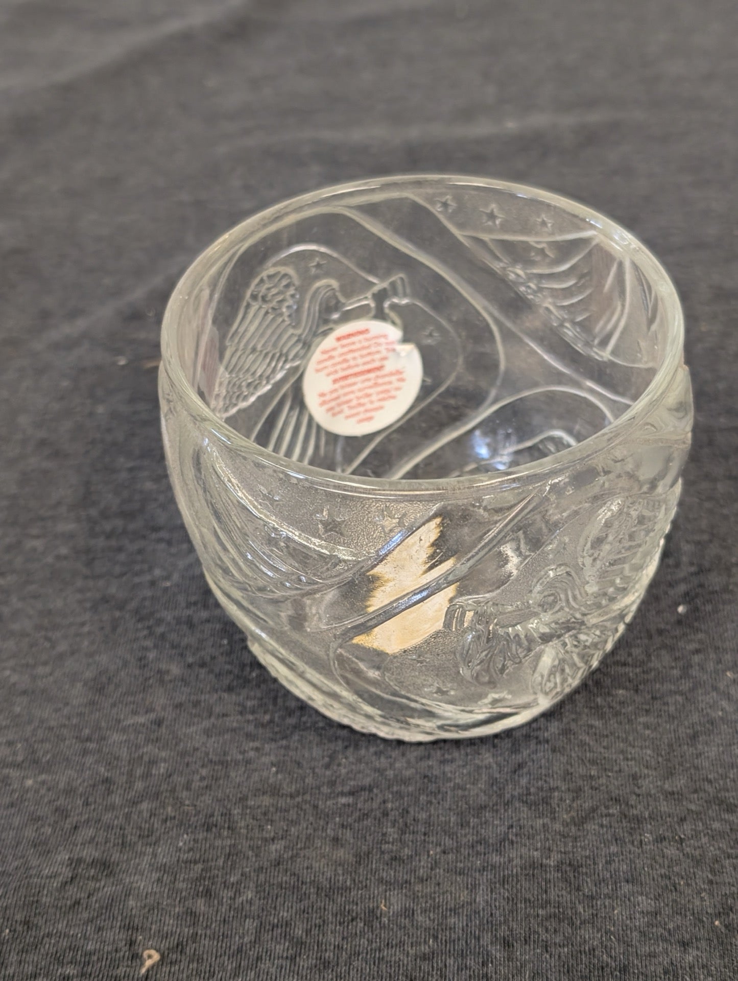 Clear glass bowl-shaped candle holder with etched eagle and stars