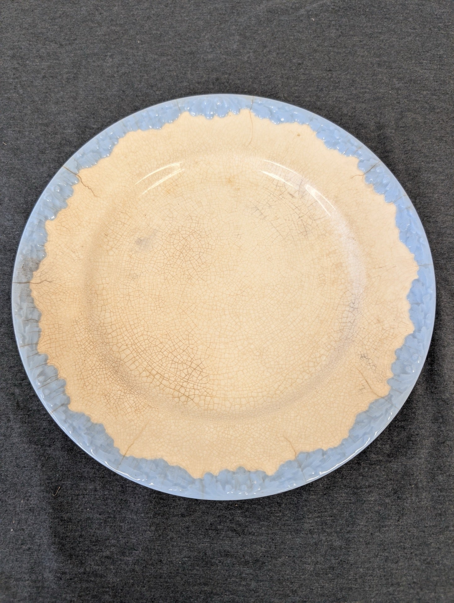 Heavily crazed cream plate with a light blue textured leaf rim.