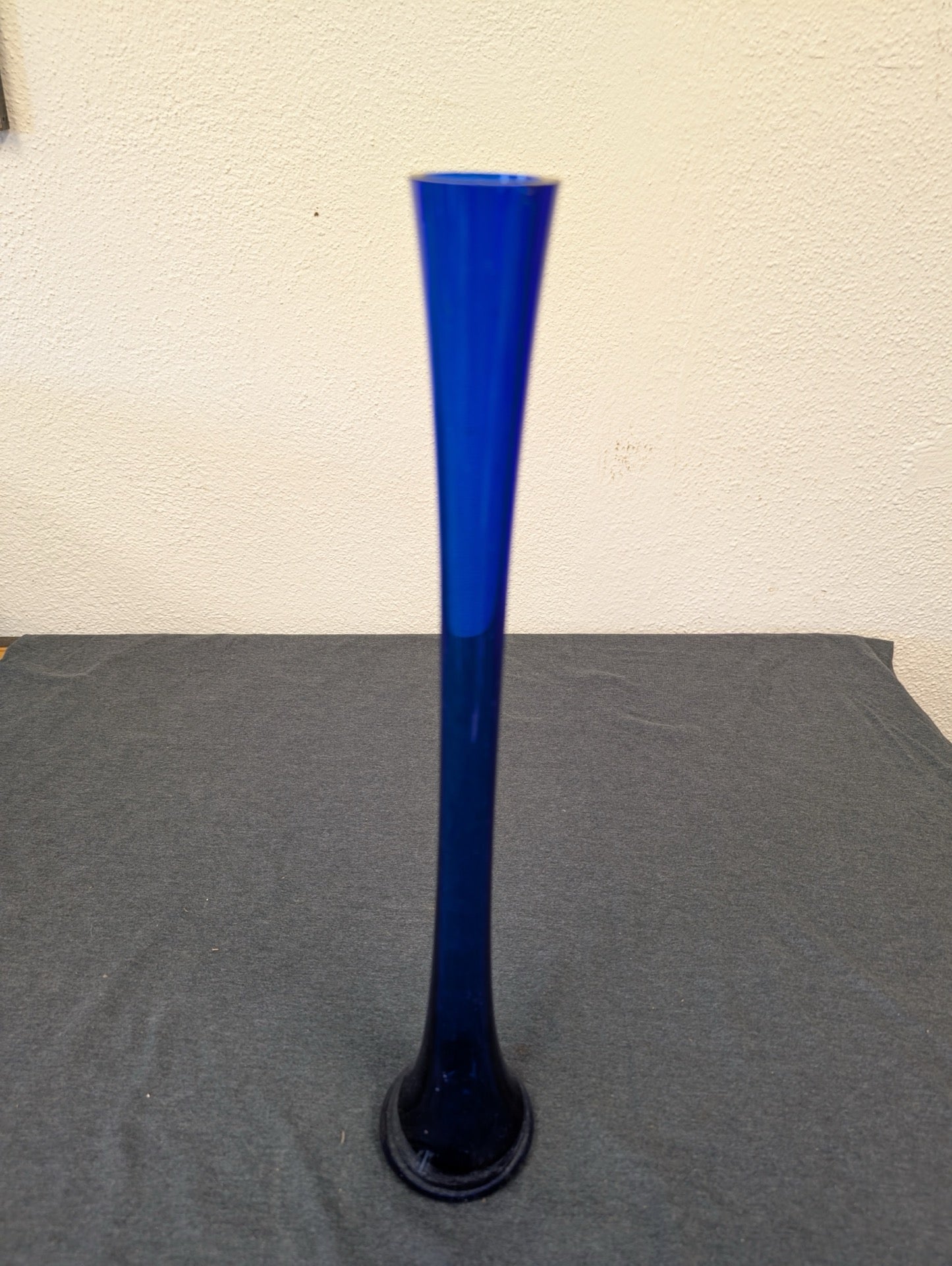 Tall slender fluted cobalt blue stretch glass bud vase.