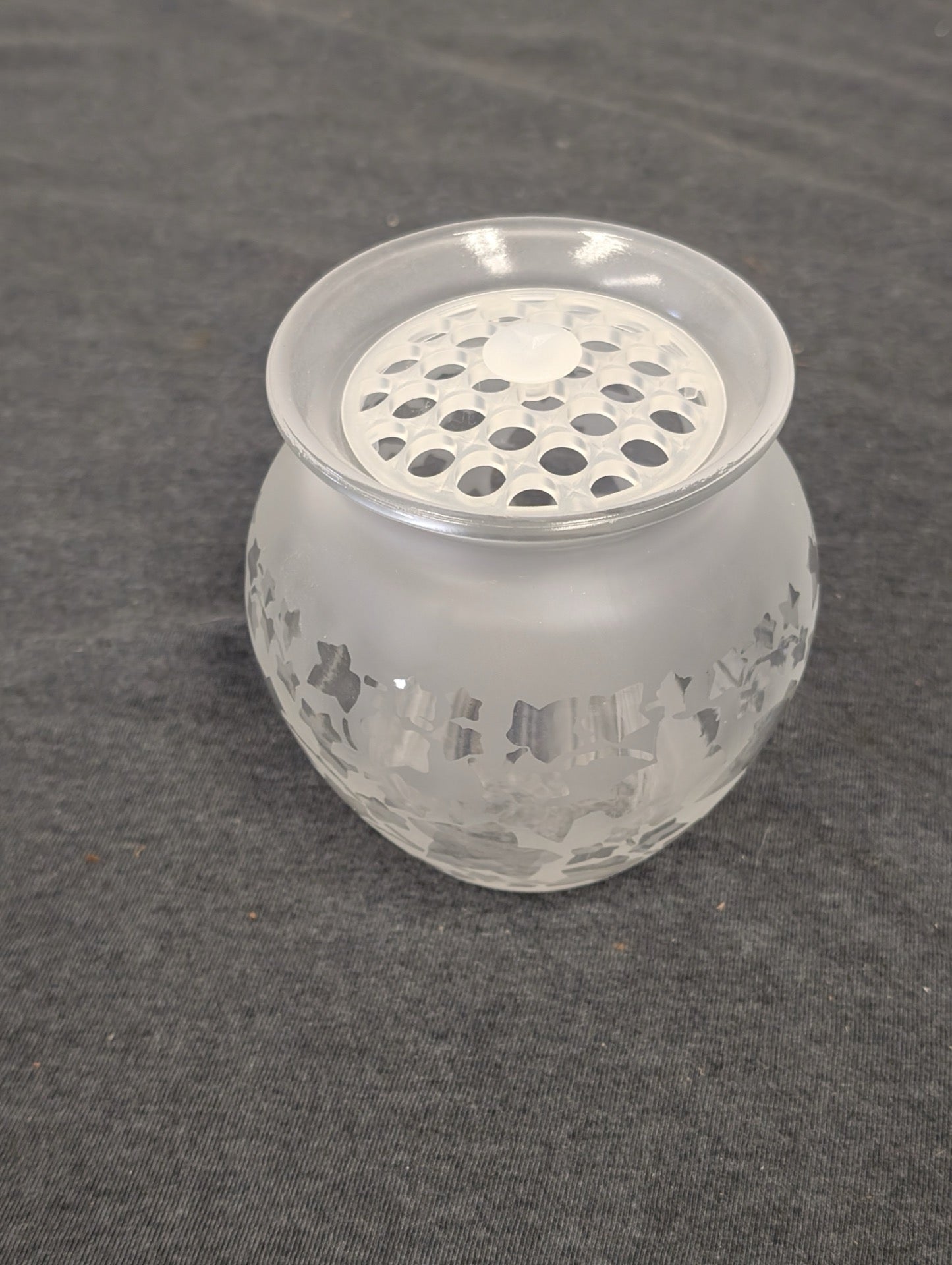 Round frosted glass vase with an etched ivy pattern and a clear glass flower frog lid.