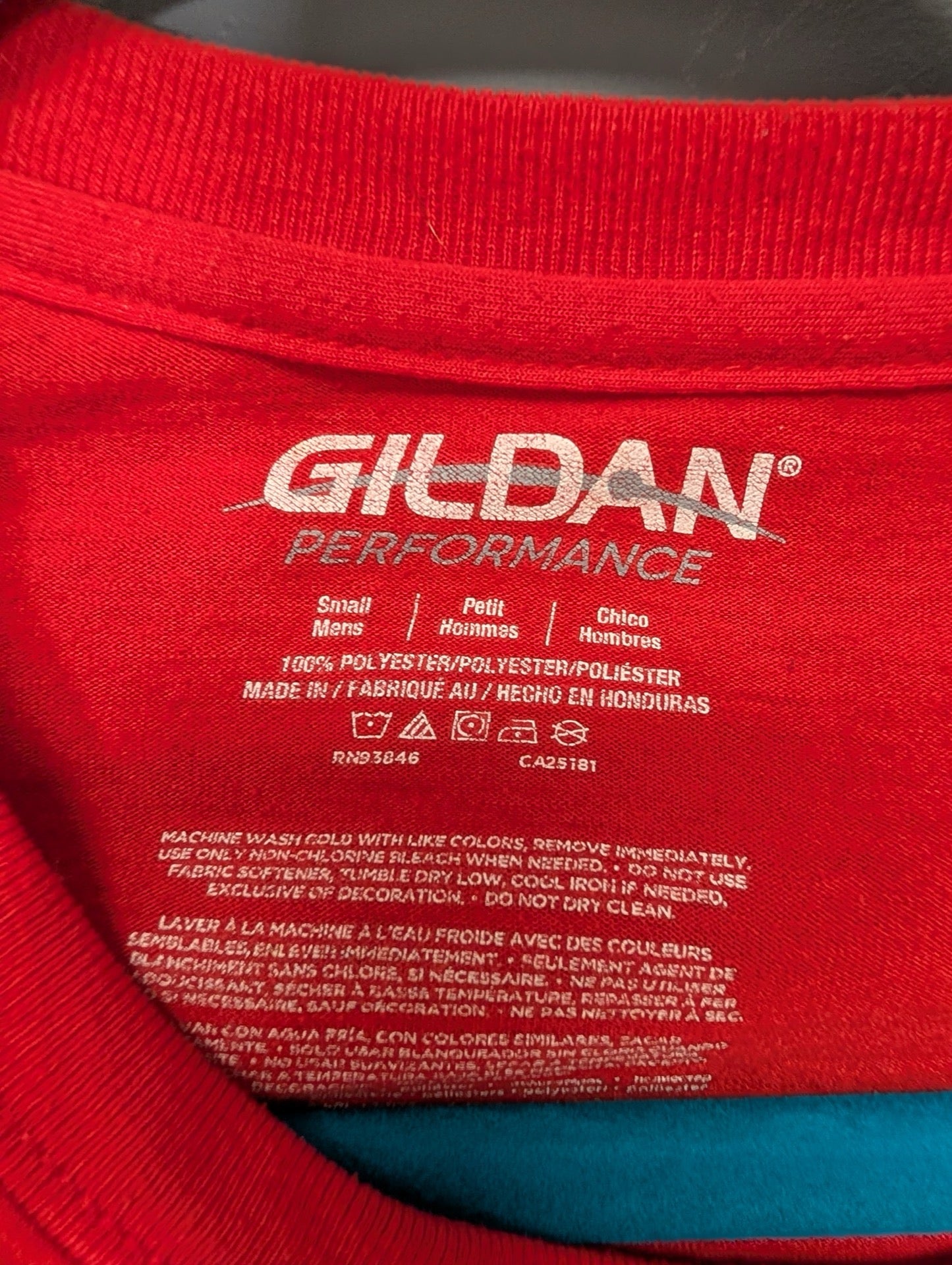 Gildan Performance size small tag on red shirt