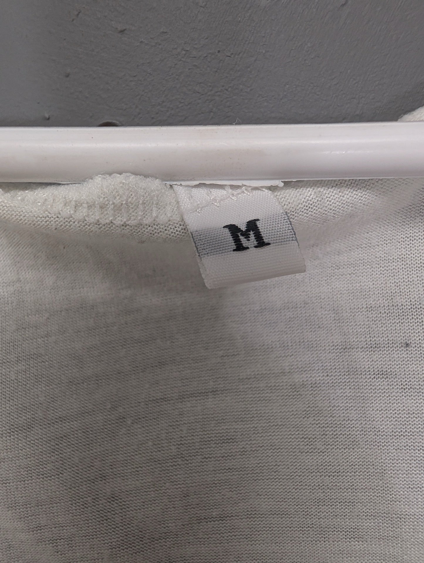 Size medium tag on white top
