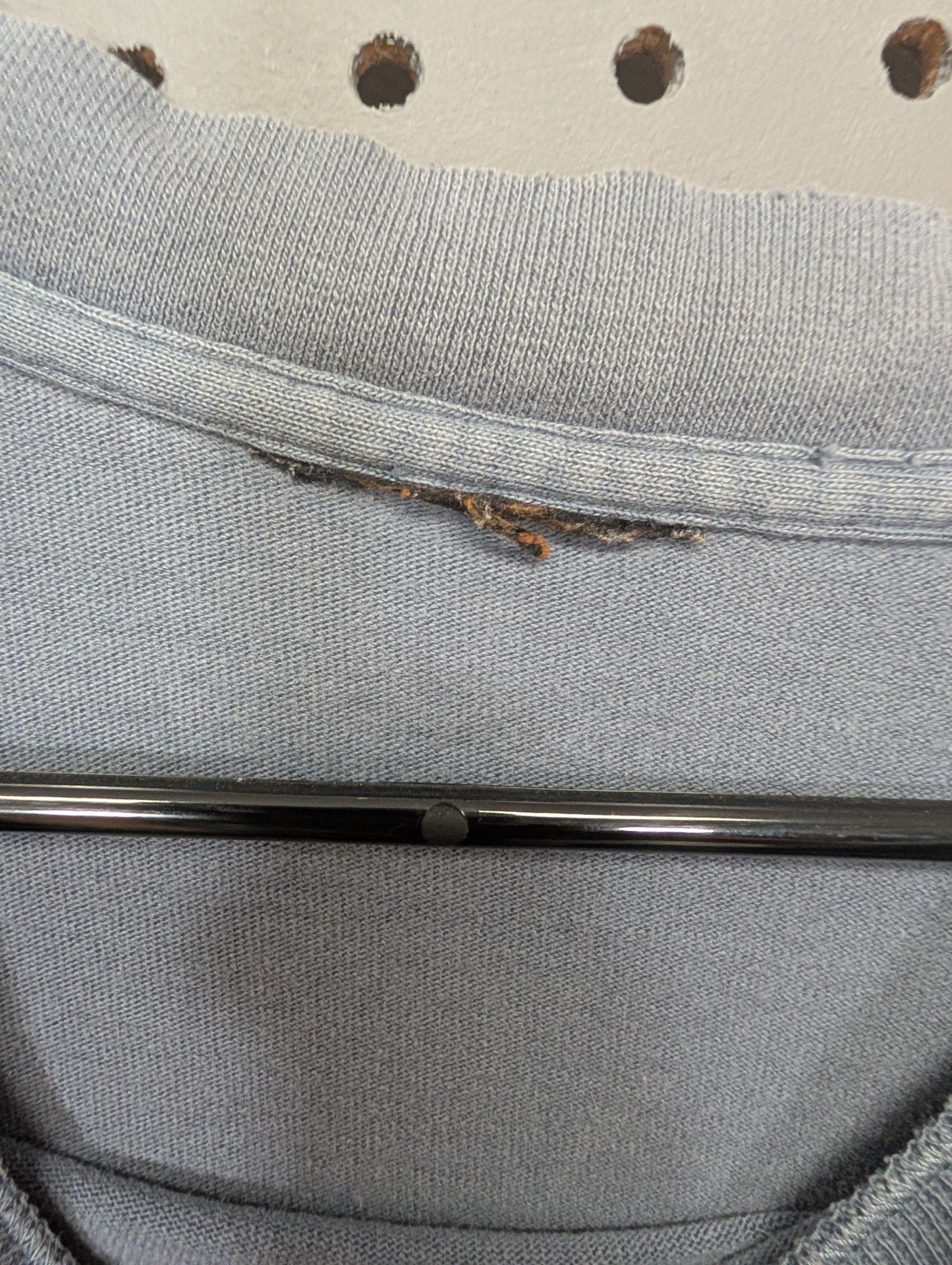 Heavily worn and frayed collar tag detail
