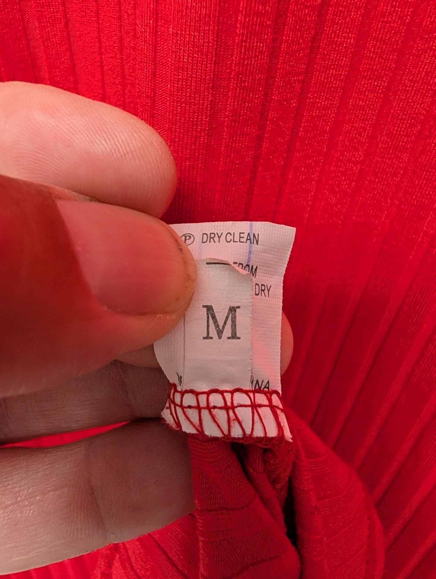 Size tag of red dress size medium