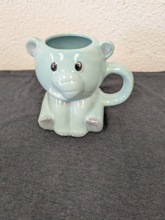Light pastel blue ceramic mug shaped like a cartoon elephant.