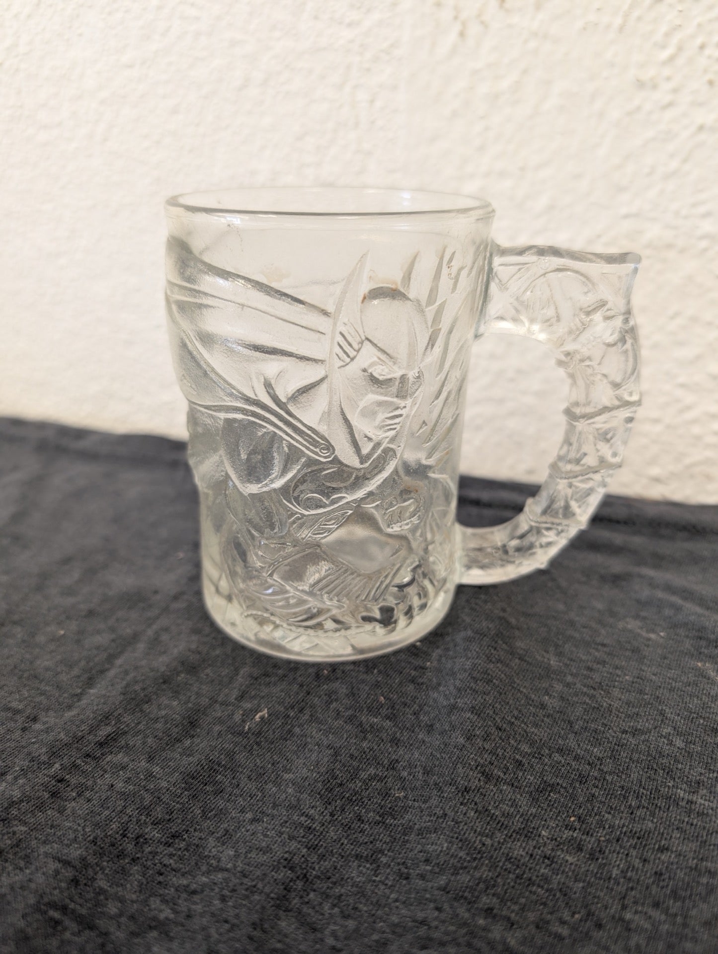 Clear glass mug with an embossed 3D figure of Batman and an ornate handle.