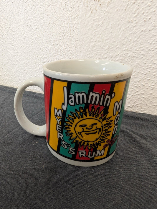White ceramic mug with colorful vertical stripes and a sun face graphic for Myers's Rum.