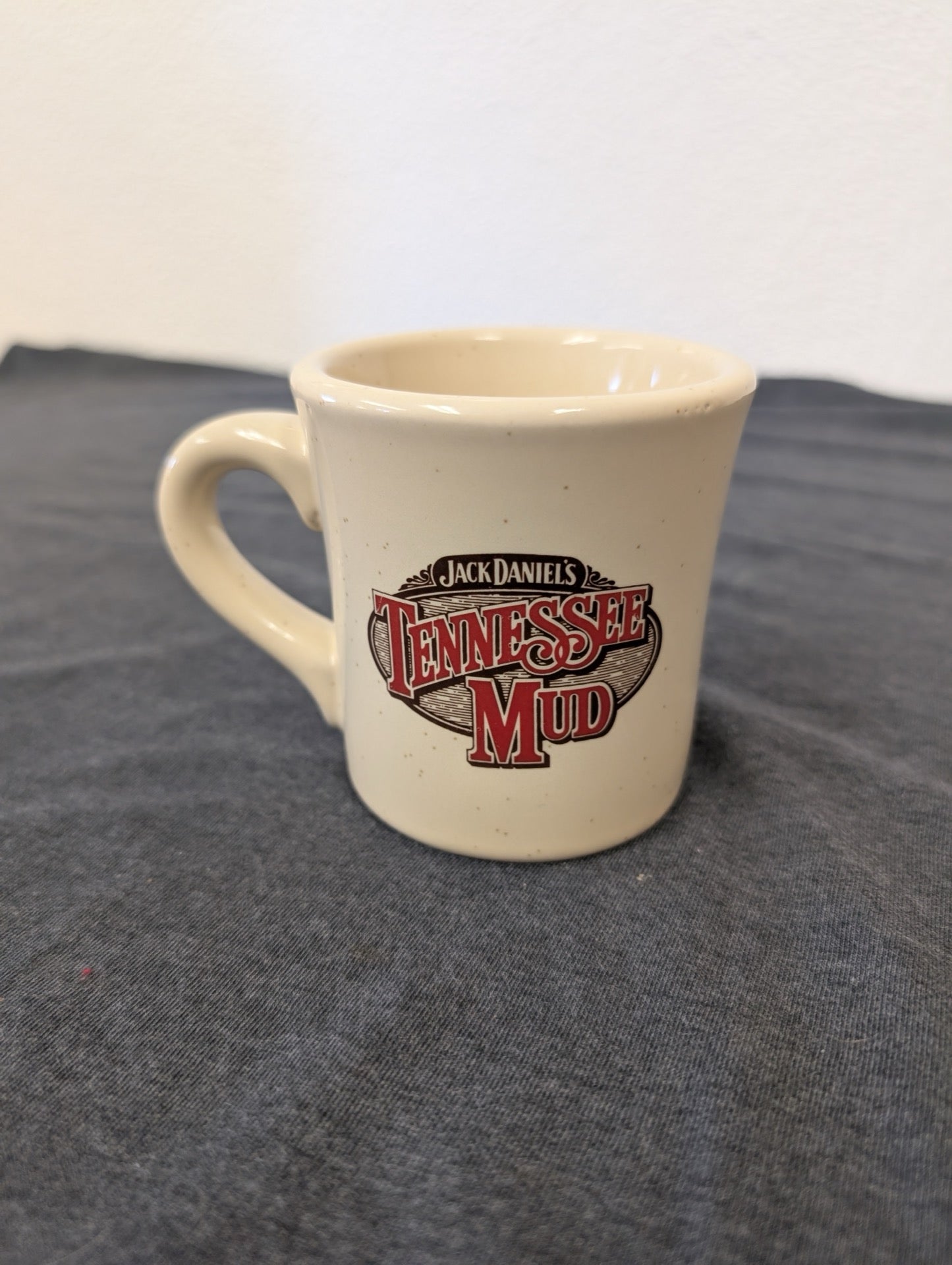 Tan diner-style thick coffee mug featuring the Jack Daniel's Tennessee Mud logo.