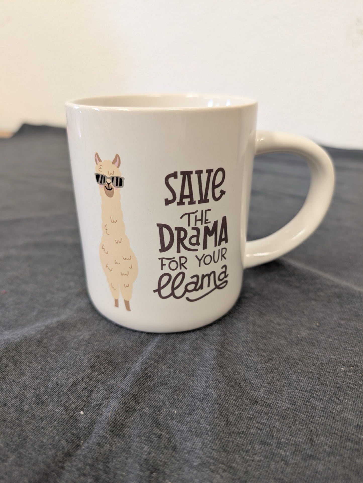 White coffee mug featuring a cartoon llama wearing sunglasses and text Save the Drama for Your Llama.