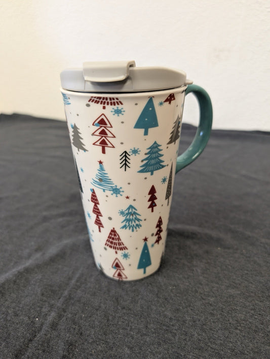 Tall ceramic travel mug with a pattern of various Christmas trees and a grey lid.