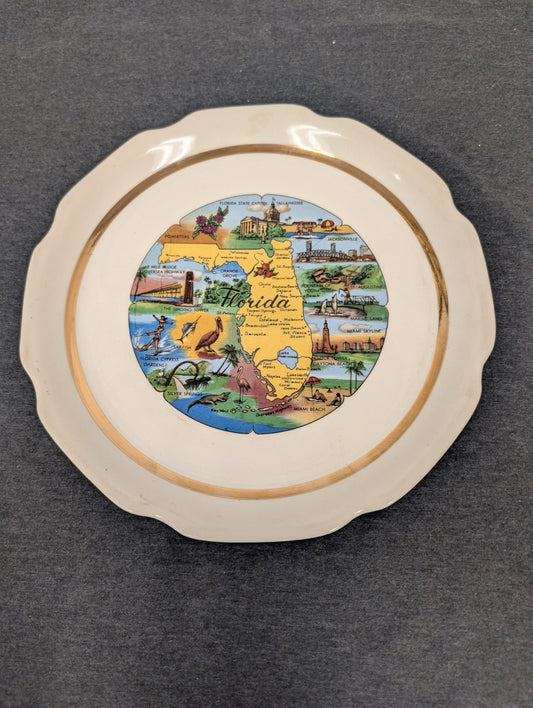 White plate with gold trim featuring a colorful map of Florida and local landmarks.