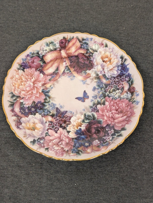 Porcelain plate featuring a dense wreath of pink peonies, purple flowers, and a blue butterfly.