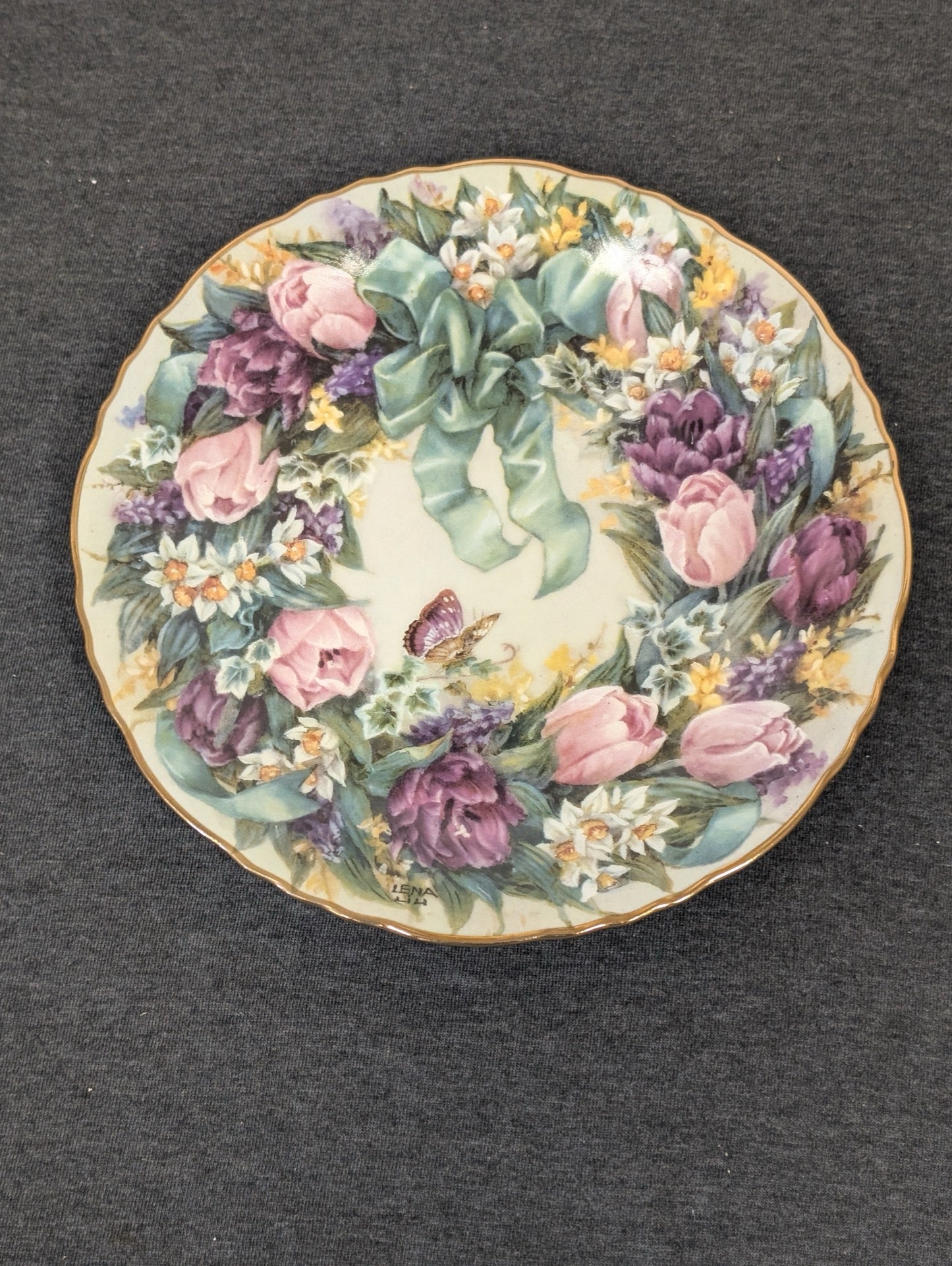 Porcelain plate featuring a wreath of pink and purple tulips, daffodils, and a teal bow.