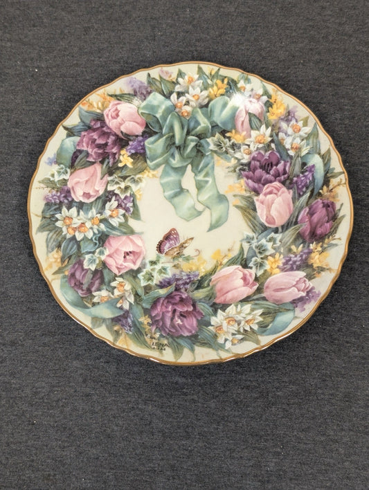 Porcelain plate featuring a wreath of pink and purple tulips, daffodils, and a teal bow.