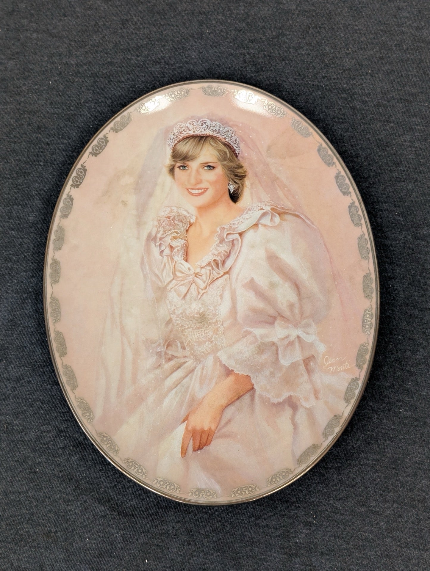 Oval porcelain plate featuring a painted portrait of Princess Diana in a gown and tiara.