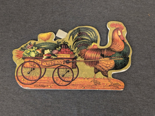 Shaped ceramic plaque of a large rooster pulling a wooden express wagon filled with vegetables.