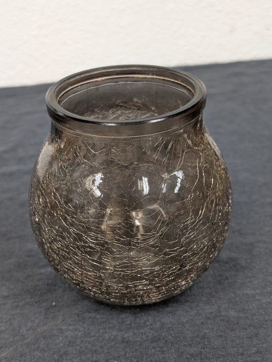 Close-up of a brown, round crackle glass jar showing detailed texture.