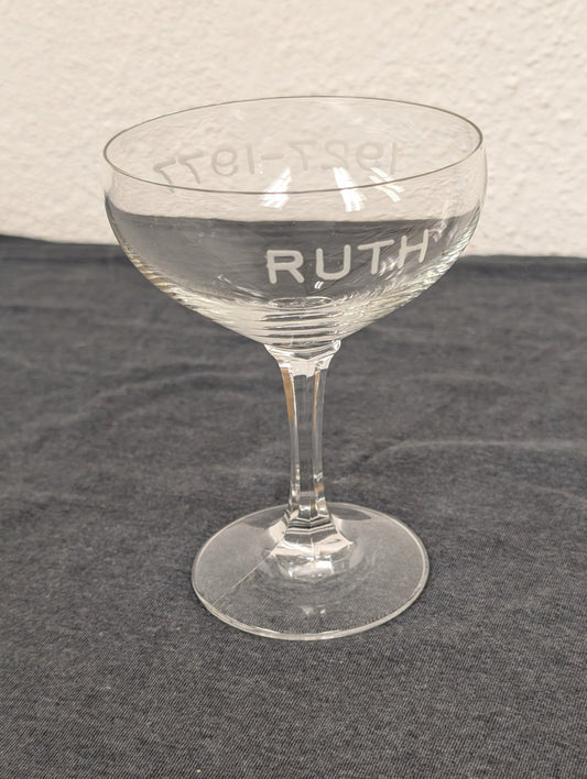 Single clear coupe glass with RUTH and 1927-1977 etched into the side.