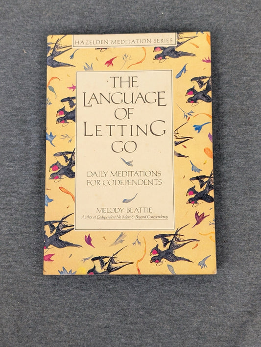 Cover of The Language of Letting Go by Melody Beattie with a yellow bird pattern.