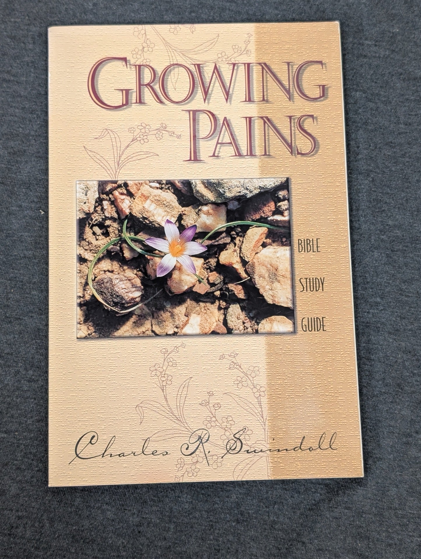 Cover of Growing Pains Bible Study Guide by Charles R. Swindoll featuring a small flower among rocks.