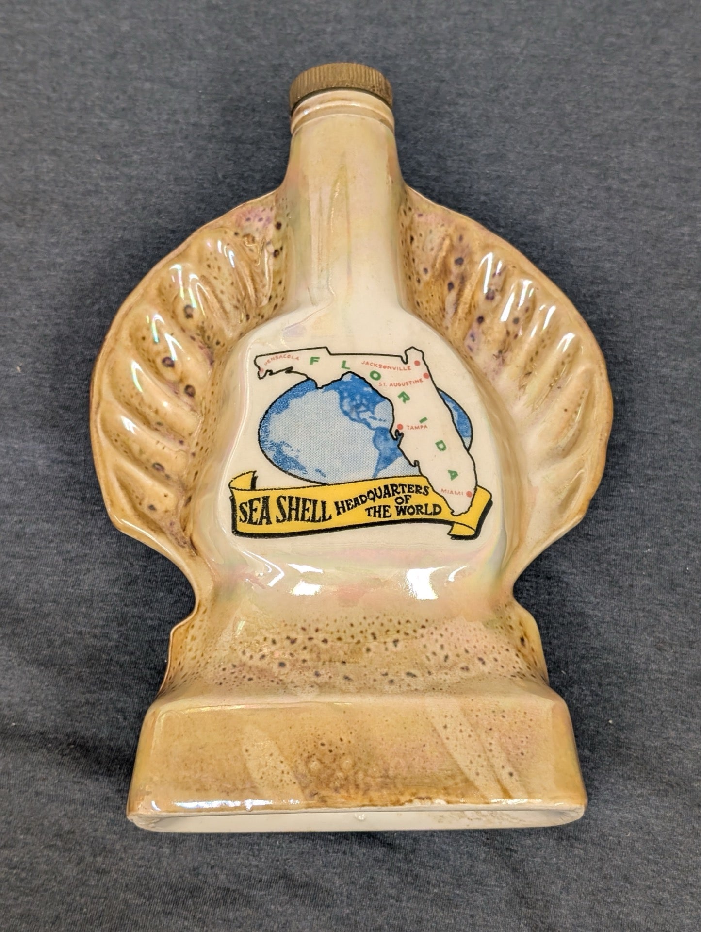 Ceramic souvenir bottle shaped like a shell reading Sea Shell Headquarters Florida.