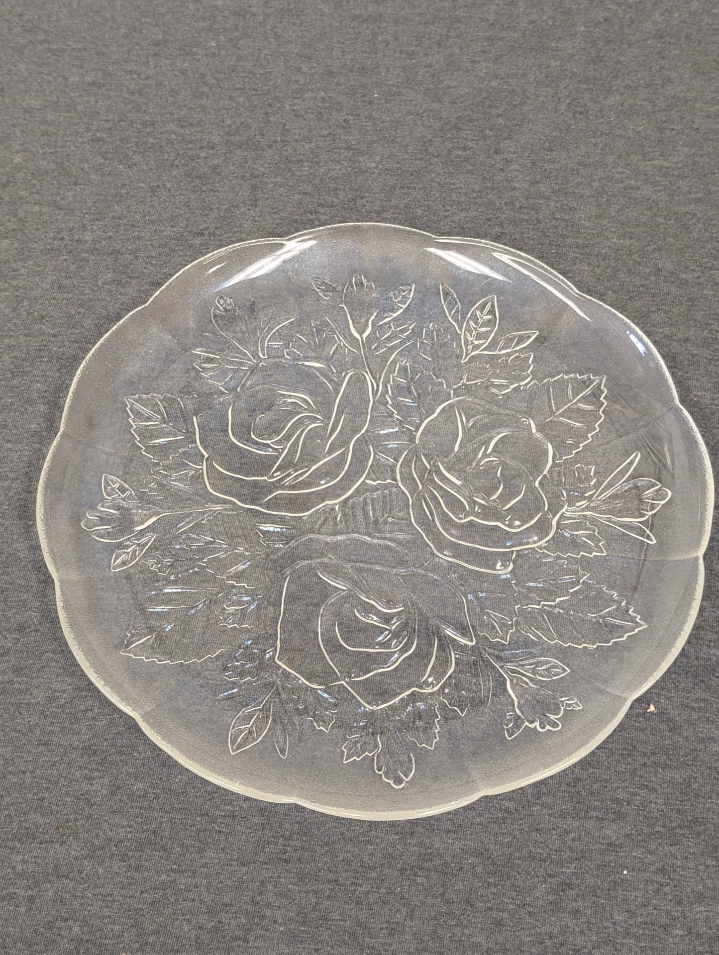 Clear glass plate with an embossed design of three large roses and leaves.