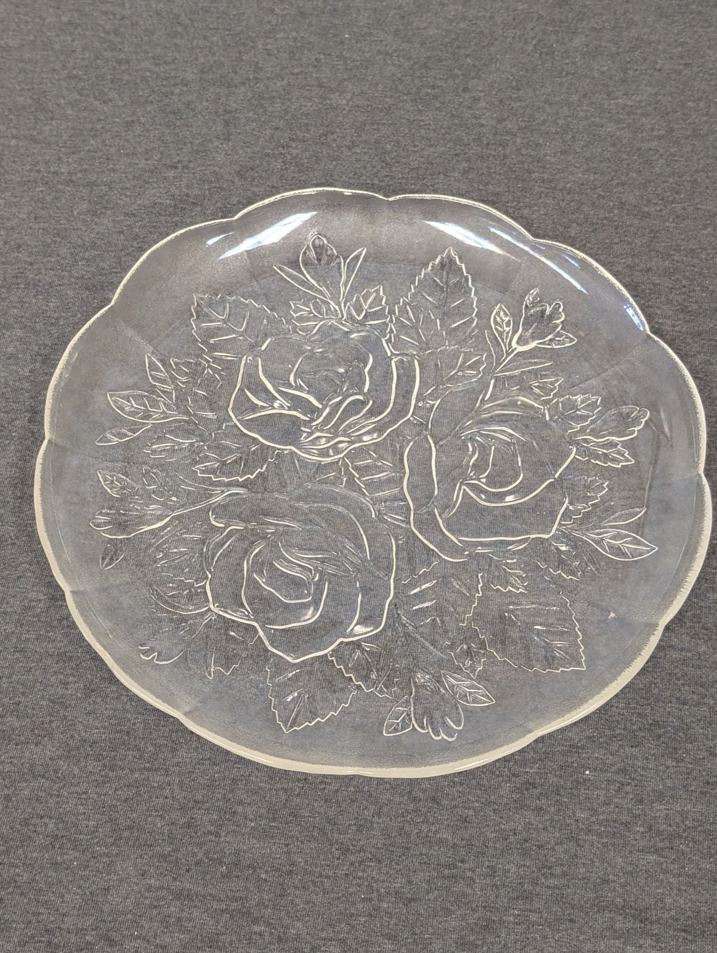 Clear glass plate with an embossed design of three large roses and leaves.