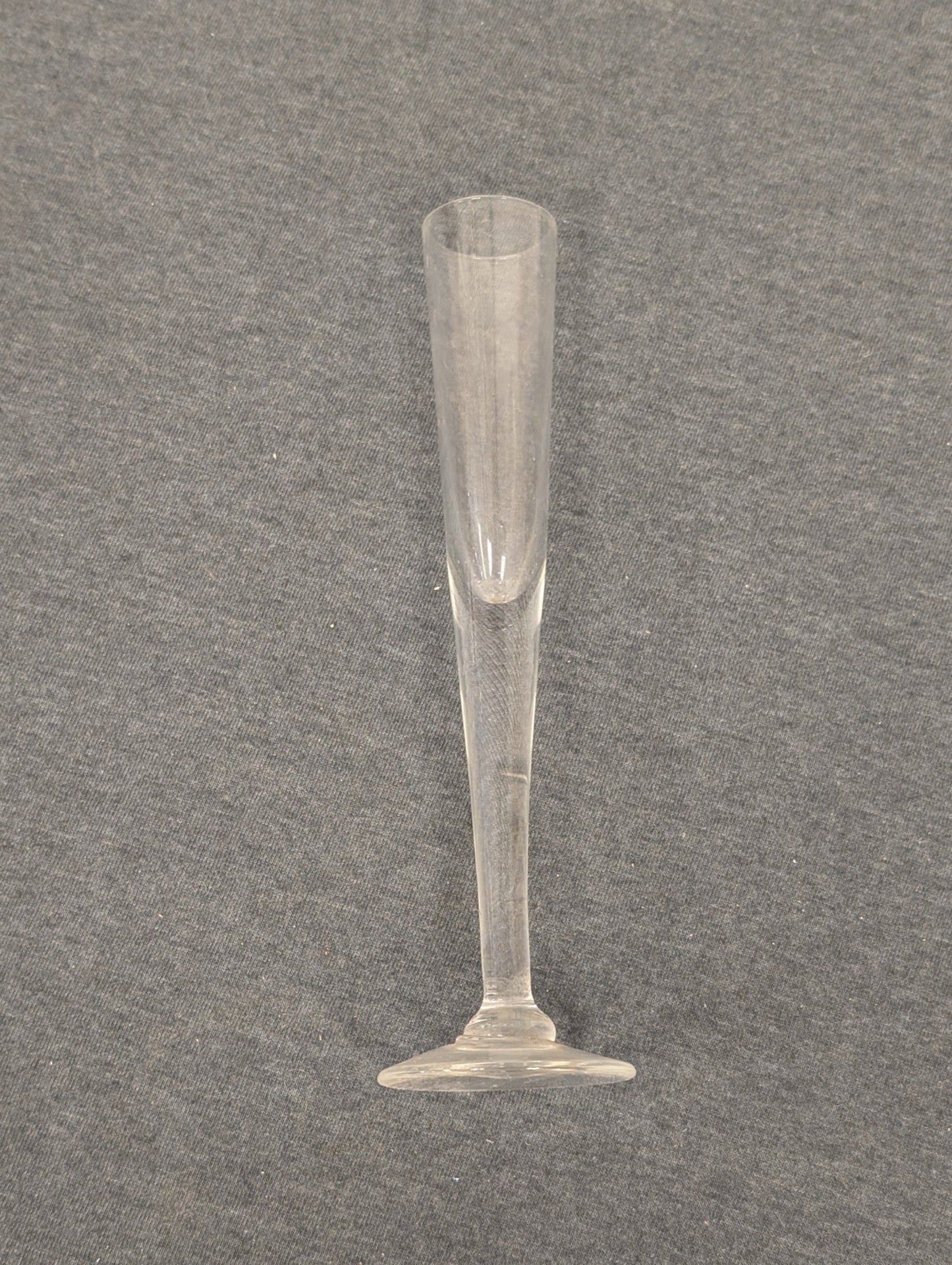 Sleek vintage clear glass champagne flute with a conical bowl.