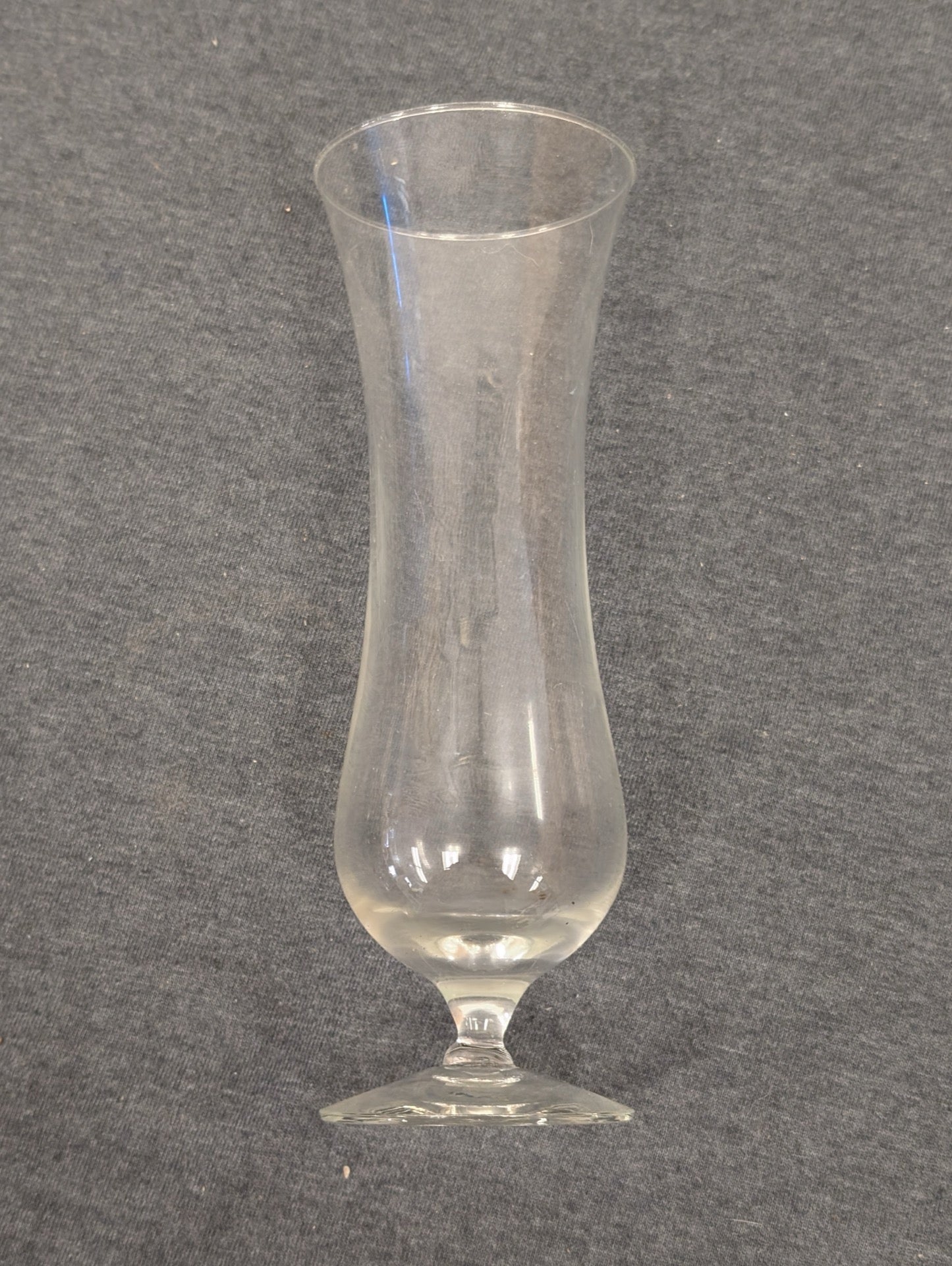 Clear glass stemware with a curvy tulip or hurricane shaped bowl.