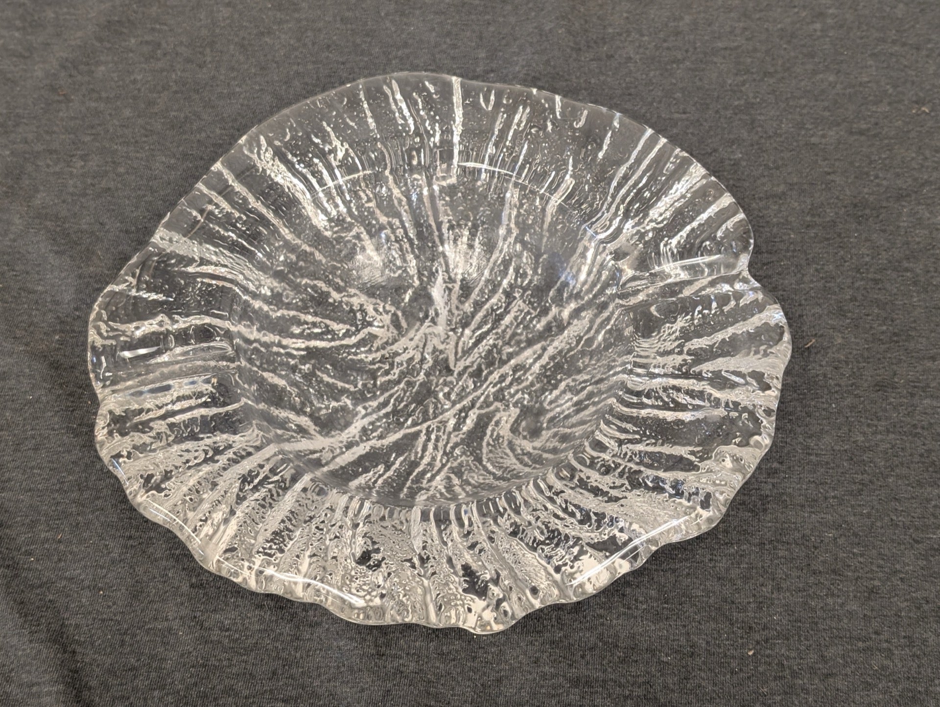 Clear glass plate with a heavy, rugged texture and uneven freeform edges.
