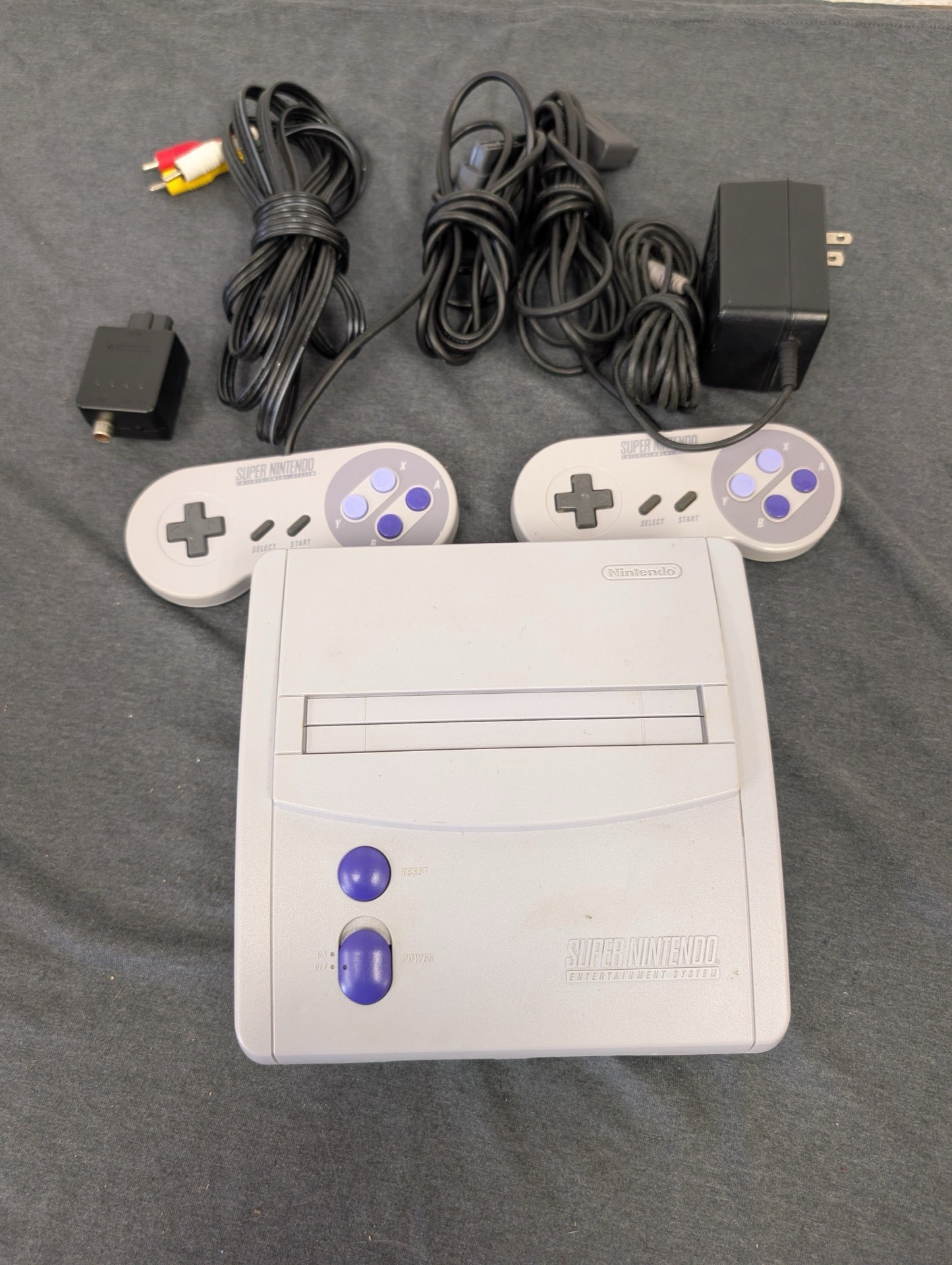 Super Nintendo console with two controllers, power adapter, AV and RF cables
