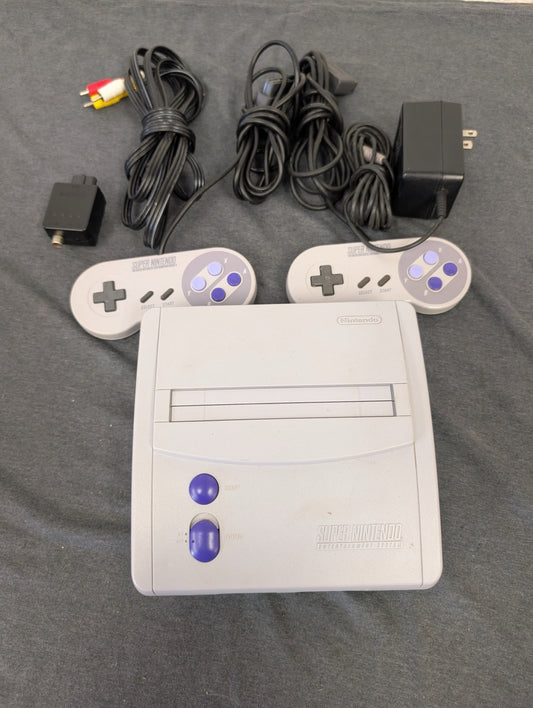Super Nintendo console with two controllers, power adapter, AV and RF cables