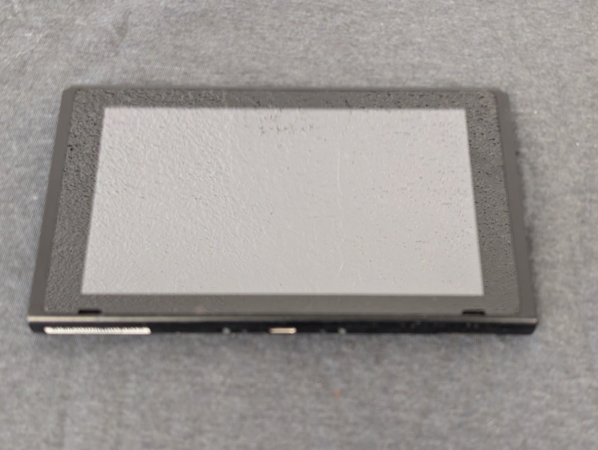 Front of a Nintendo Switch tablet screen showing heavy wear