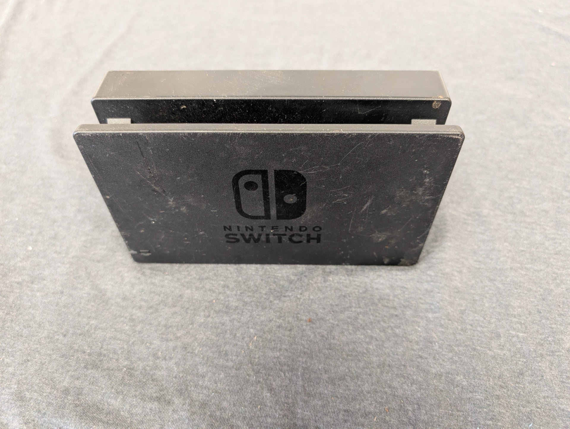 Black Nintendo Switch TV dock showing scuffs and scratches