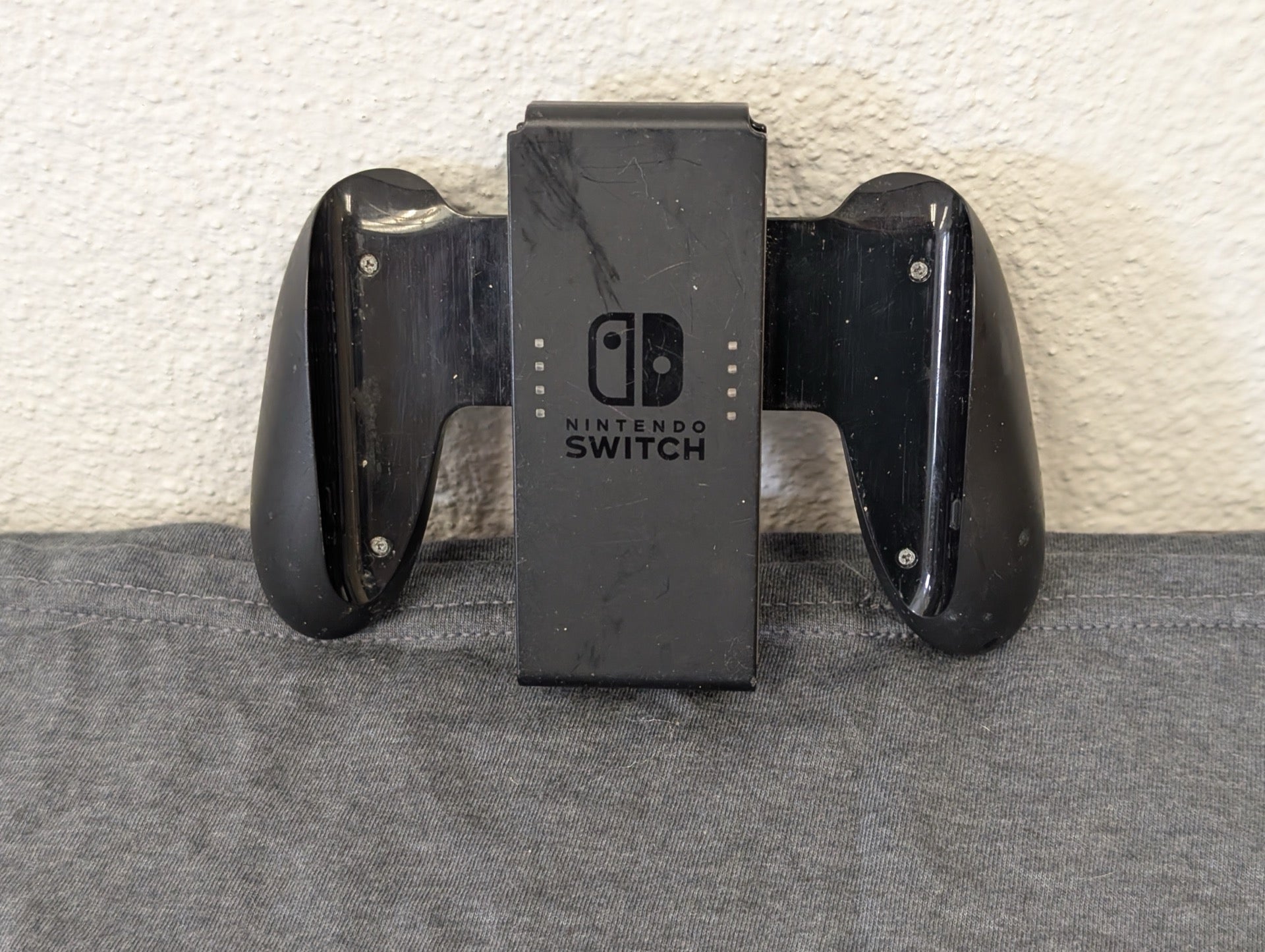 Official Nintendo Switch Joy-Con grip with heavy scratching