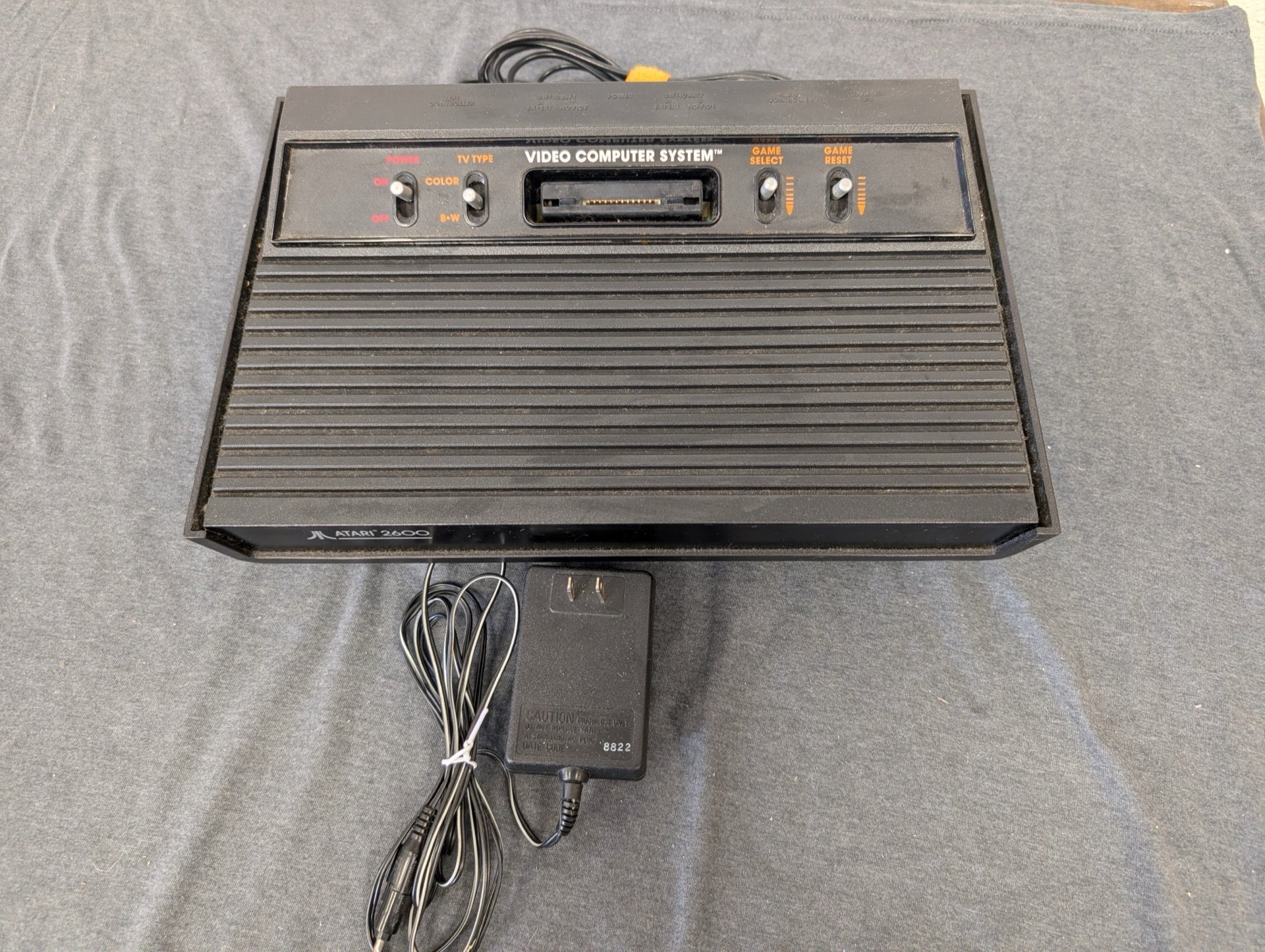 Black Atari 2600 4-switch console with power adapter.