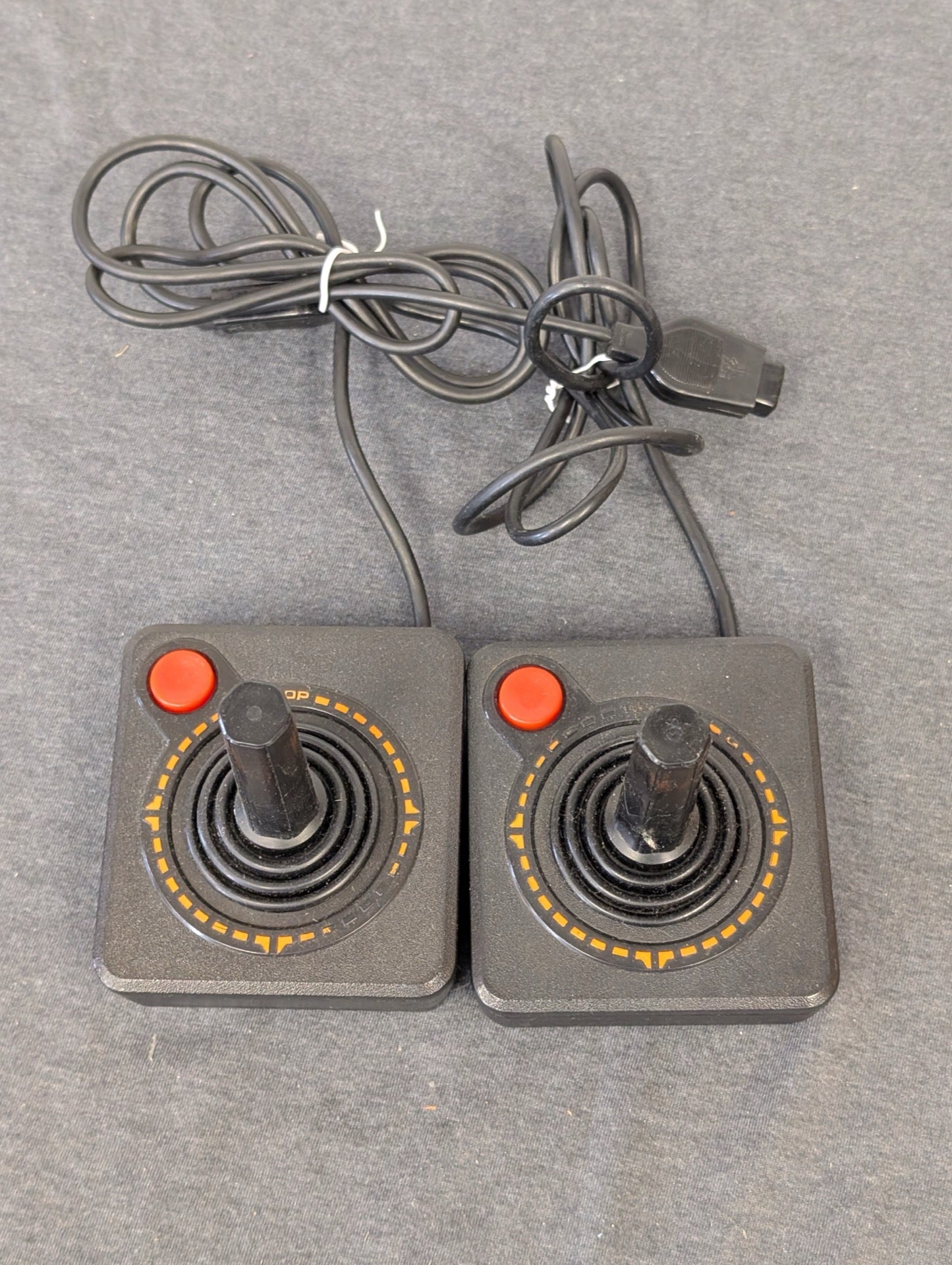 Two vintage black Atari CX40 joysticks side by side.