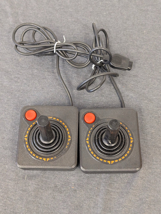 Two vintage black Atari CX40 joysticks side by side.
